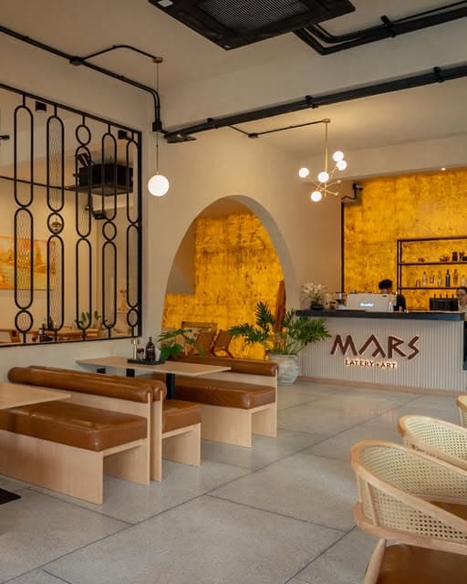 Interior of MARS Eatery and Art with a gold-leaf bar wall, arched niches and timber banquettes